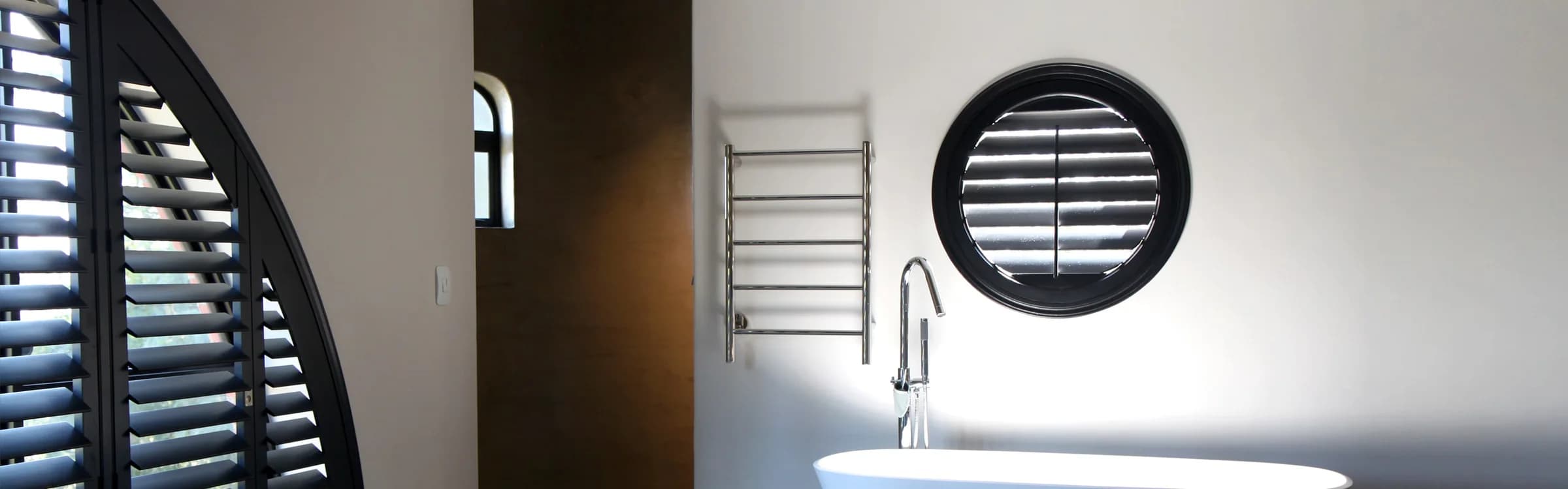 Dark shutters following the curve of an arched opening