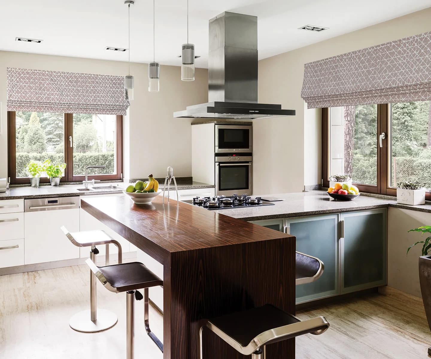 Patterned Roman shades framing two windows in a modern kitchen