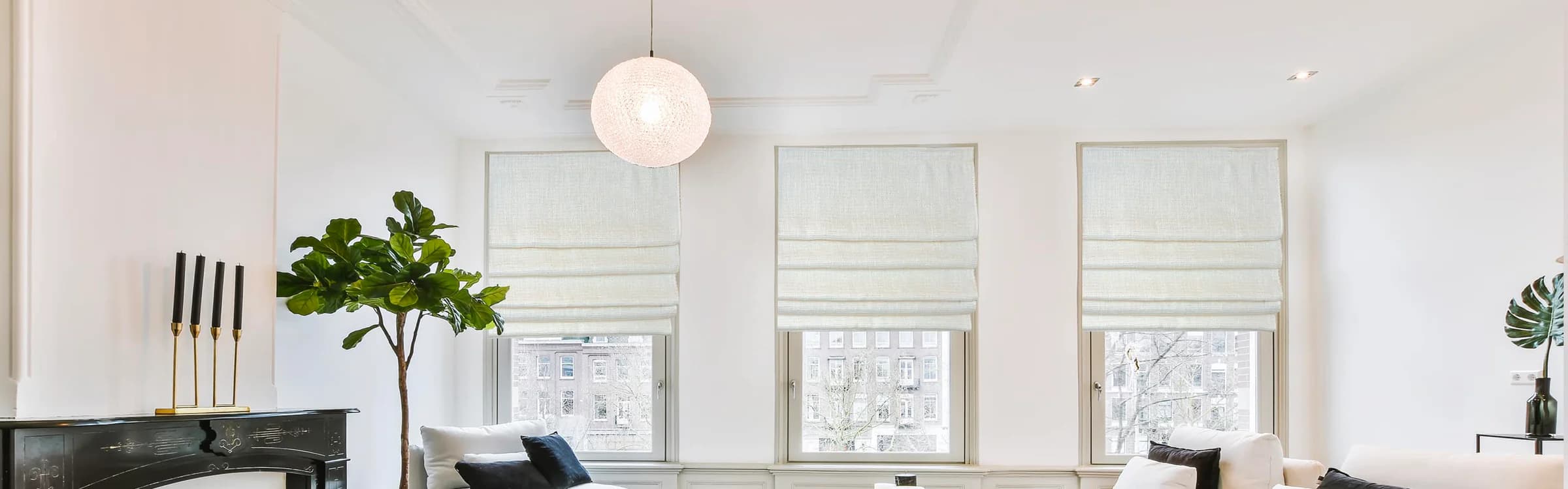 White Roman shades filtering light in an airy living room