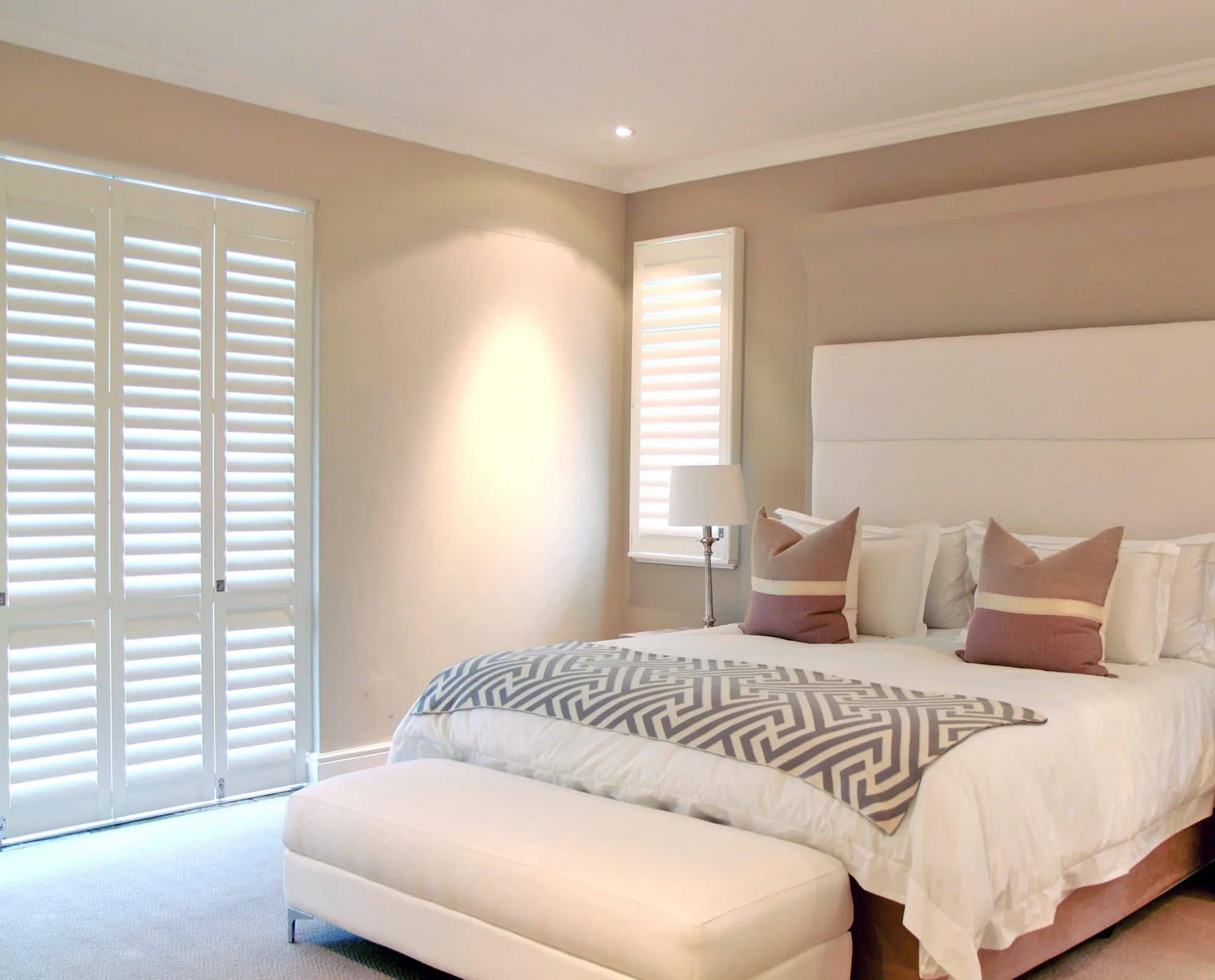 White shutters fitted neatly in a warm bedroom