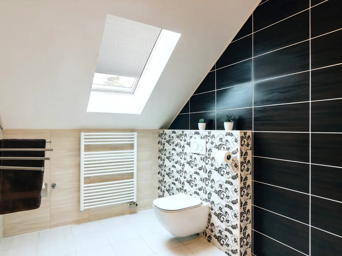 A cellular shade fitted within a sloped bathroom skylight