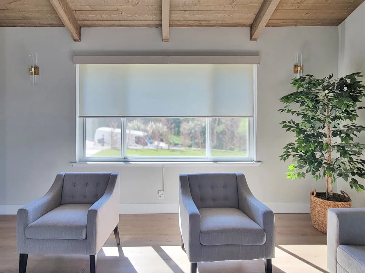 Solar shades managing glare above a pair of lounge chairs