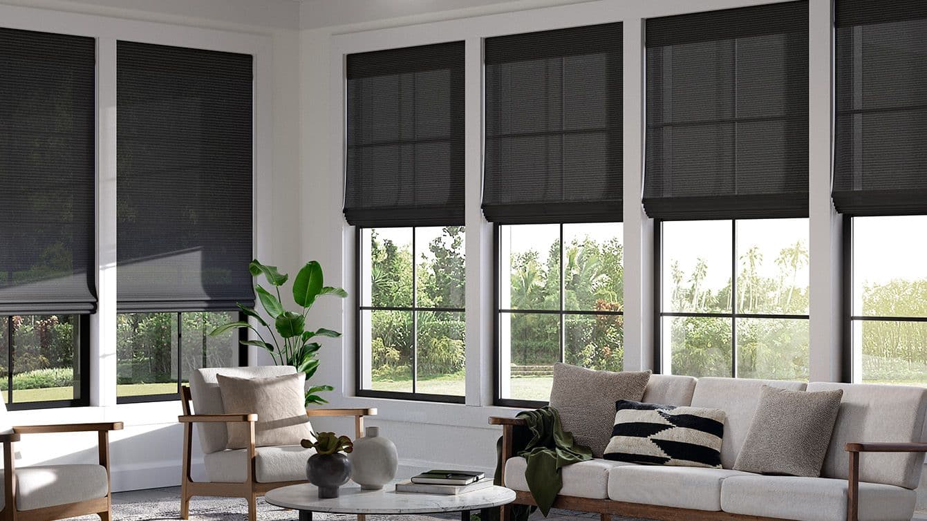 Dark woven shades across a sunroom window wall
