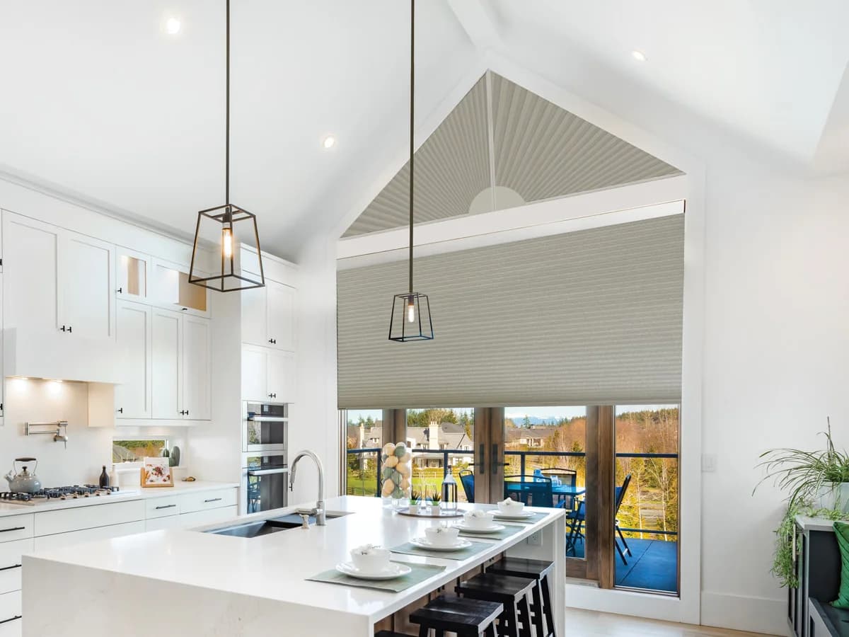 Cellular shades covering a tall angled window and adjacent door