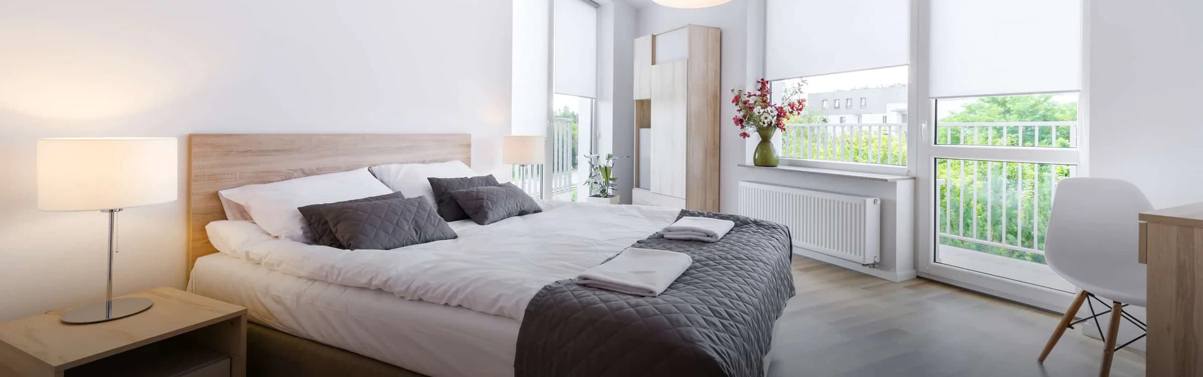 Neutral roller shades balancing light in a Scandinavian bedroom