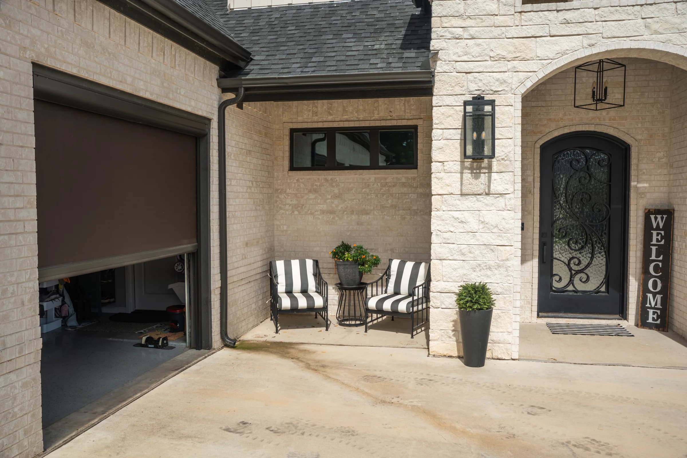 A motorized exterior screen lowered across a residential garage opening