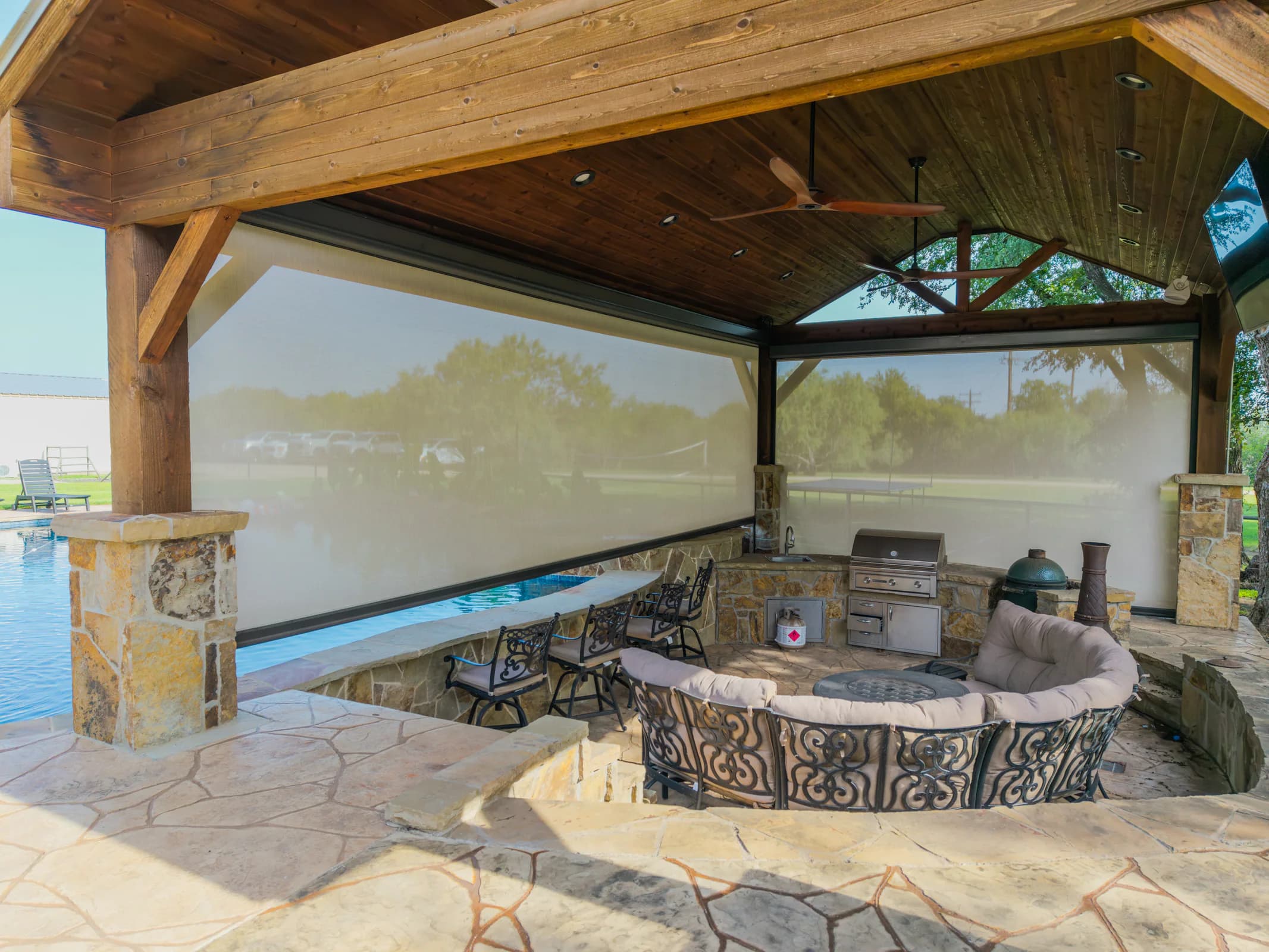 Exterior solar screens enclosing a timber-framed outdoor kitchen
